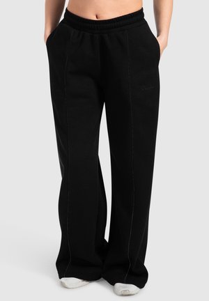 Pantaloni sportivi neri con una vestibilità rilassata, vita elastica, tasche laterali e dettagli di cucitura a contrasto. Realizzati in un tessuto morbido per il massimo comfort.
