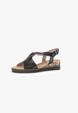 Schwarze Leder-Sandalette mit offenem Zehenbereich, verdrehtem Riemen, verstellbarer Schnalle am Knöchel, gemustertem Keilabsatz und strukturiertem schwarzen Gummiprofil.