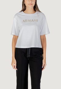 Witte cropped t-shirt met een ronde halslijn en korte mouwen, voorzien van een metallic gouden "ARMANI EXCHANGE" logo aan de voorkant.