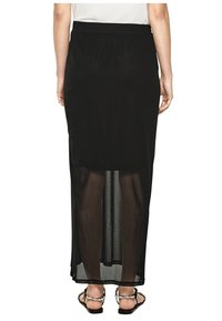 Svart maxikjol med ett genomskinligt panel längst ner, tillverkad av lättviktig tyg. Har en elastisk midja och en enkel, flödande design.