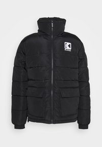 Giacca trapuntata nera con zip frontale, tasche a soffietto, polsini elastici, colletto alto e logo "KANI" bianco sul petto.
