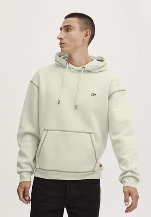 Light green hoodie made of soft fabric, featuring a front pocket, drawstring hood, and contrasting stitching. Small logo on chest.