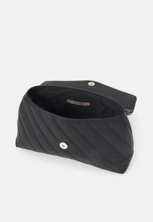 Schwarze gesteppte Handtasche mit goldfarbenem Knopfverschluss, geöffnet, um das Innenfutter aus Stoff und ein kleines Etikett mit der Aufschrift "Anna Field." zu zeigen
