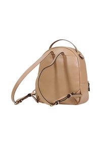 Beige läderryggsäck med rundad form, justerbara remmar och ett övre handtag. Har detaljer i guldfärgad metall och en strukturerad yta.