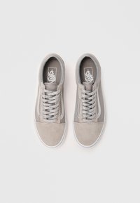 Gray suede sneakers with white rubber soles, featuring silver laces and a classic side stripe design. Textured mesh lining and logo on tongue.