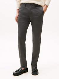 Grå chinos i lätt tyg, med smal passform, slät front och sidofaror, ihopparade med svarta loafers med tofsdetalj.