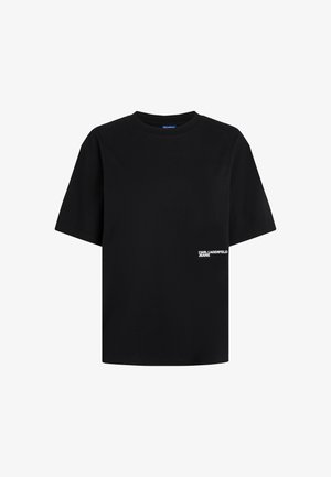 Must beebi musta t-särk, mis on valmistatud puuvillast. Omab ümmargust kaelust ja väikest valget logo teksti vasakul ees.