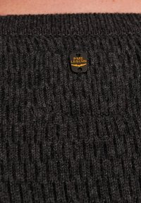 Schwarzer gestreifter Strickpulloverstoff mit einem sichtbaren Markentag, auf dem "PME LEGEND" in Gold steht. Der Stoff hat eine glatte Textur und auffällige Nähte.