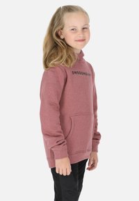Maroon hoodie with a kangaroo pocket and a high neck, featuring black "SWEDEMOUNT" text on the chest. Worn with dark pants.