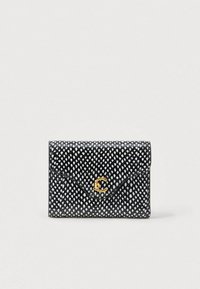 Juodas ir baltas piniginės ra�štas, imituojantis gyvatės odą, su išlenktu atvartu ir auksiniu tarpusavyje persipynusiu CC logotipu priekyje, prieš šviesų foną.