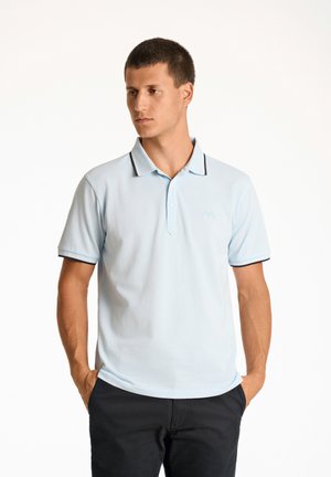 Camisa polo de color azul claro con cuello, ribete oscuro y un logotipo bordado en el lado izquierdo del pecho. Manga corta y un diseño de corte clásico.