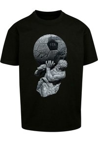 Sort t-shirt med en grå skulptur af en figur, der holder en tekstureret fodbold med "FCH" trykt på.