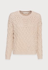 Béžový pletený svetr s copánkovým vzorem, kulatým výstřihem a dlouhými rukávy. Texturovaná látka s otevřenými oky dodává vizuální zajímavost.