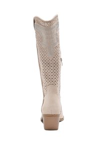 Botín de tobillo beige hecho de ante perforado con punta puntiaguda y un tacón de 5 cm. Costuras decorativas y acentos en plata en el caño.