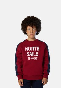 Felpa rossa con accenti blu navy, dotata di grafica "NORTH SAILS 1957" sul davanti. Maniche e colletto a coste, realizzata in materiale morbido.