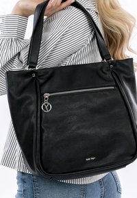Sac fourre-tout en cuir noir avec une surface texturée, une poche zippée argentée et un porte-bijoux de marque. Poignées doubles pour un transport facile.
