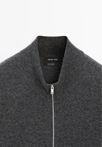Tmavě šedý kašmírový svetr na zip s žebrovaným límcem a stříbrným zipem, označený značkou Massimo Dutti, vyrobený v Kambodži.