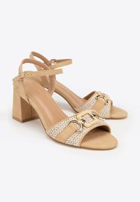 Beige Sandalen mit Blockabsatz und offenen Zehen, mit geflochtenem Vorderband, goldfarbenen Schnallen und Fußgelenkriemen mit kleinen verstellbaren Schnallen.