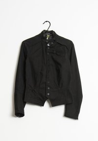 Svart, figursydd jacka med hög krage, knappstängning framtill och långa ärmar. Den har en slät yta och en lätt midjeinsnävning.