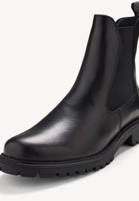 Bottines Chelsea en cuir noir avec panneaux latéraux élastiques, bout arrondi, semelle épaisse basse et semelle texturée pour une meilleure adhérence. Fini lisse et brillant.