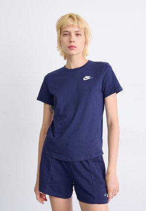 T-shirt en coton bleu marine à manches courtes et col rond, avec un logo Nike blanc sur la poitrine gauche et un short bleu marine assorti.