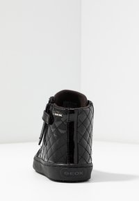 Svart kviltad lackläder ankelboot med dragkedja på sidan, gummisulor och en liten logotyp på baksidan. Mjuk inre foder.