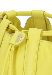 Borsa a tracolla gialla in pelle con una finitura testurizzata, dotata di manico superiore e dettagli in metallo dorato. Design plissettato e interno liscio.