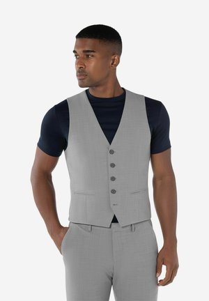 Grijze gilet, slim fit ontwerp, enkelvoudig met vijf knopen, twee zijzakken, gecombineerd met een zwart T-shirt met ronde hals. Soepele textuur.