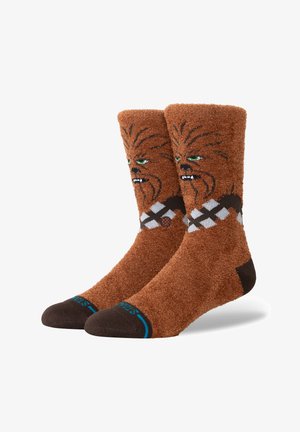Hnedé, chlpaté ponožky s textúrovaným povrchom. S dizajnom Chewbaccu, zelenými očami a čierno-bielym vzorom v oblasti členku.