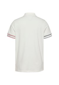 Camisa polo blanca con cuello y mangas cortas, con acentos a rayas rojas y marinas en los puños, fabricada en suave tela de algodón.