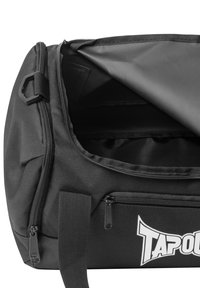 Bolsa de deporte negra con un compartimento principal con cremallera, bolsillo frontal y asas reforzadas. Presenta una tela texturizada y un detalle de logo.