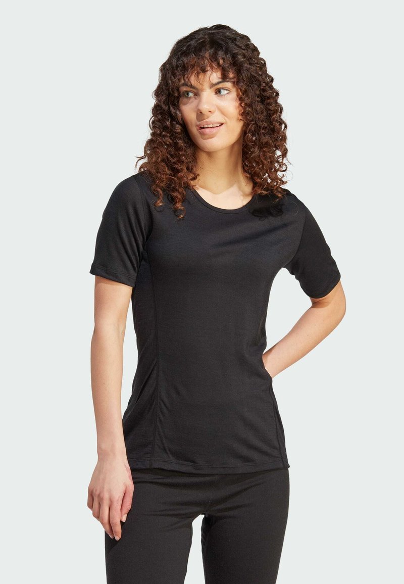 Black short-sleeve T-shirt made from soft fabric with a round neckline and side ruching details, paired with black bottoms.