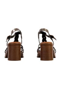 Sandali a tacco quadrato marroni con cinturini metallici, fibbia alla caviglia regolabile e suole textured. Presentano un design intrecciato sui cinturini.