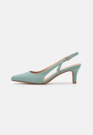 Scarpa slingback verde menta con punta appuntita, morbida texture scamosciata e un tacco modesto. Presenta sezioni ritagliate e una cinturino alla caviglia regolabile.