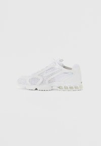 Bílé sportovní boty s síťovinovým svrškem, gumovou podrážkou a polstrovanými detaily. Výrazný design zahrnuje perforované vzory a texturované kryty.