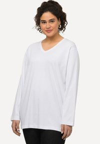 Weißes Langarm-V-Ausschnitt-Shirt aus weichem Stoff, im lässigen Schnitt und mit geradem Saum. Glatte Textur ohne Muster oder Akzente.