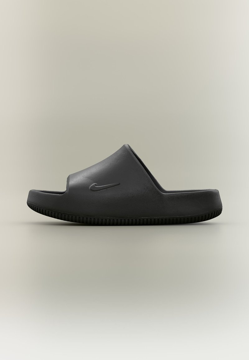 Μαύρο σανδάλι slide Nike με καλουπωμένο πέλμα και υφασμένη σόλα, εμφανιζόμενο σε πλευρική προφίλ σε ουδέτερο φόντο.