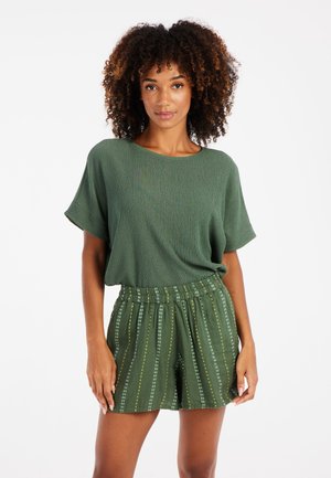 Green ribbed knit top with short sleeves paired with green elastic waistband shorts featuring vertical white and yellow stripes.