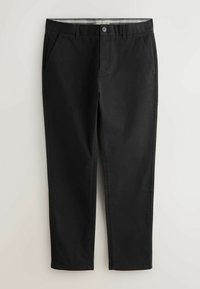 Mustat slim-fit-housut, joissa on etutaskut, vyölenkit ja nappikiinnitys, aseteltuna tasaiselle vaalealle taustalle.