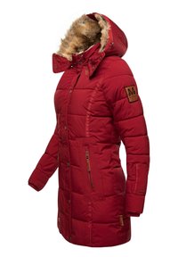 Red puffer jacket with fur-lined hood, quilted texture, front buttons, and side zippered pockets. Features branded patch on sleeve.