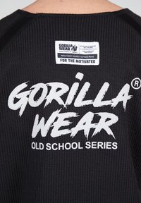Zwarte sweatshirt van textuurstof met vet wit tekst "GORILLA WEAR" en "OLD SCHOOL SERIES," met een rechthoekig logo label op de achterkant.
