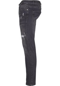 Kapeat farkut tummanharmaasta denimmateriaalista, joissa on kulutettuja yksityiskohtia. Ominaisuuksiin kuuluvat viisi taskua, nappikiinnitys ja hillitty haalistuminen kankaan pinnalla.