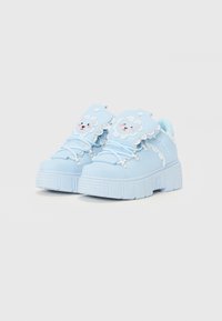 Jasnoniebieskie sneakersy na platformie z teksturowaną podeszwą, z akcentami sznurków oraz z motywem lwa na języku. Wzmocnione detale szycia.