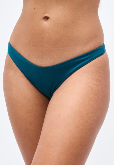 Βυθός μαγιό σε τυρκουάζ χρώμα με ομαλό, ελαστικό ύφασμα. Ο σχεδιασμός έχει χαμηλή μέση με μαλακές άκρες και ελάχιστη κάλυψη.
