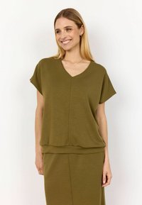 Top verde oliva a maniche corte con scollatura a V e orlo a strati, realizzato in tessuto morbido e testurizzato. Abbinato a una gonna coordinata.