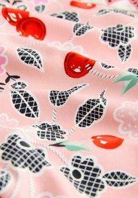 Rožinė medžiaga su gėlių ir lapų raštais, turinti raudonus akcentus ir juodus tinklo dizainus. Lygus paviršius su šiek tiek blizgesio.