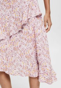 Abito midi floreale rosa con orlo a volant stratificato. Presenta motivi intricati in viola, giallo e bianco su un tessuto leggero.