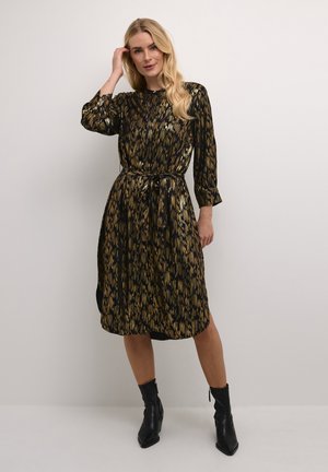 Schwarzes und goldenes gemustertes Kleid mit langen Ärmeln, einer taillierten Taille und einem Bindegürtel. Der Stoff hat ein glänzendes, strukturiertes Aussehen.