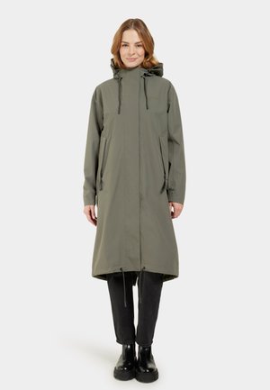Olive green long raincoat with a hood, adjustable drawstrings, two side pockets, and a relaxed fit. Black ankle boots worn underneath.