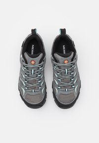 Graue Sneakers aus Mesh und Wildleder, mit hellblauen Akzenten, einer robusten Sohle und einem sicheren Schnürsystem. Orangefarbenes Logodesign.